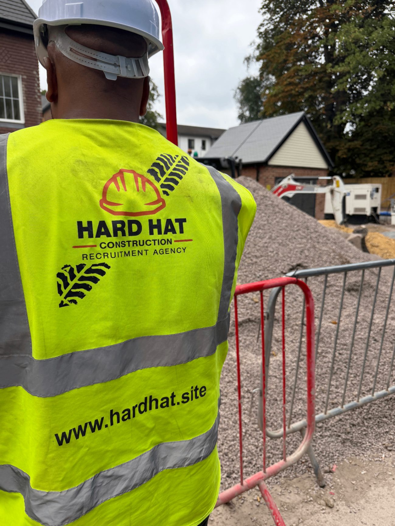 Hard Hat operative in branded hi-vis vest on a residential construction site